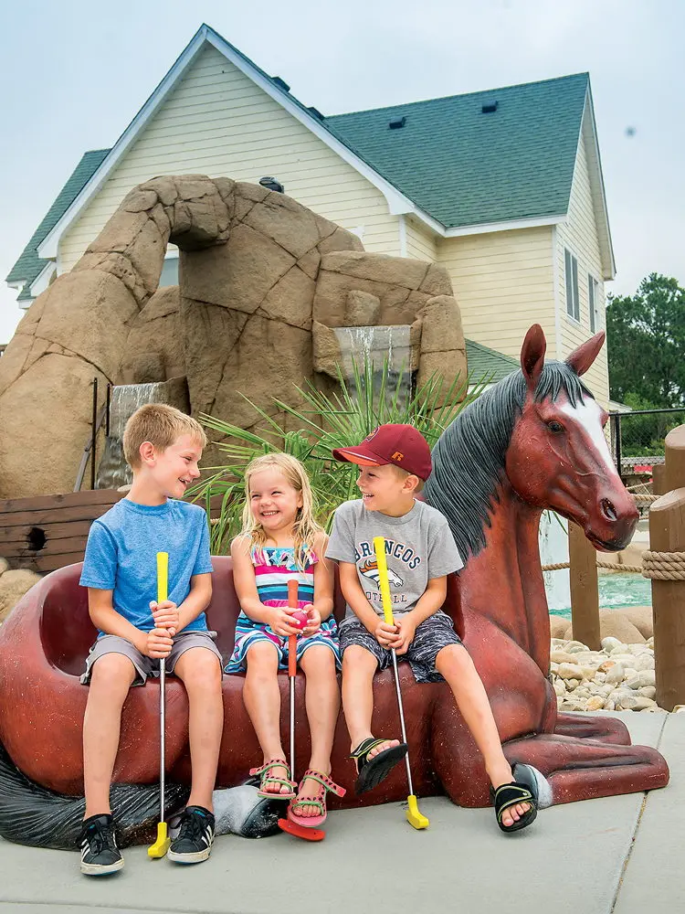 Kids playing mini golf at Pirates Island at Corolla Light Town Center